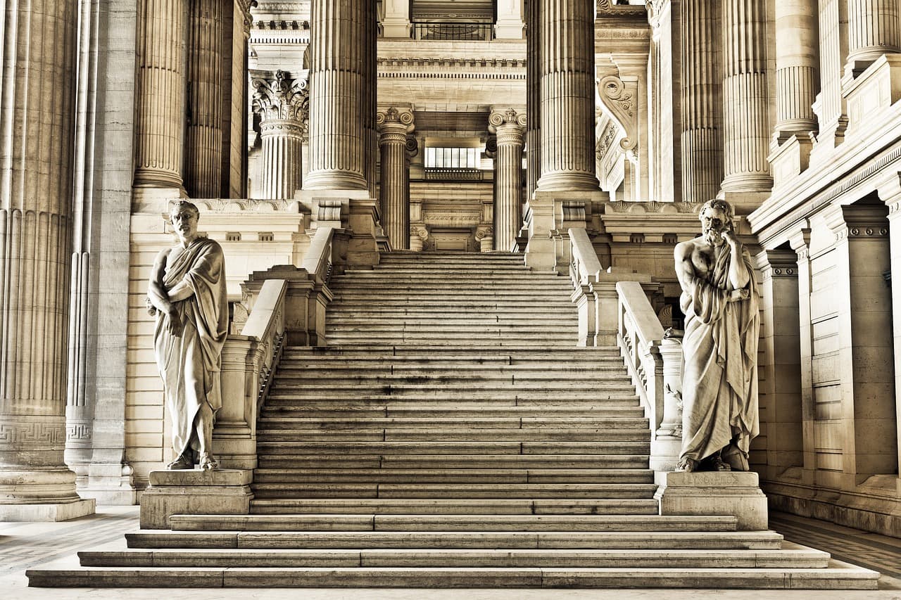 Photo of a large number of white stairs in Gothic style, with a beautiful building in the background