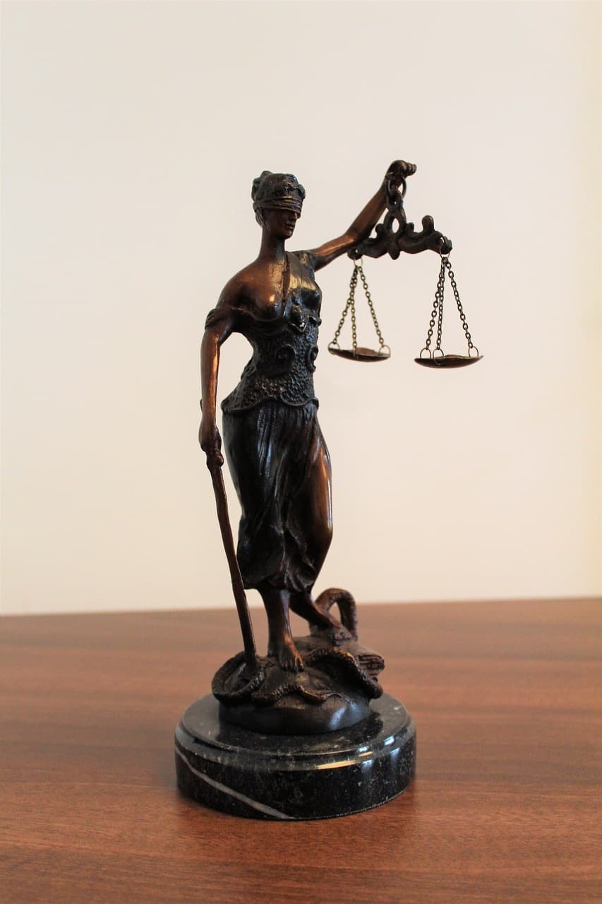 Photo of goddess venus holding scales standing on the desk